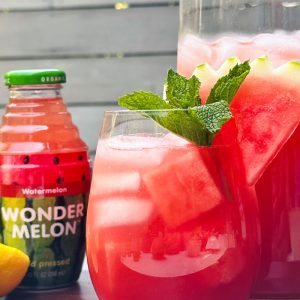 Wonder Melon bottle beside a fresh watermelon mint drink with ice.